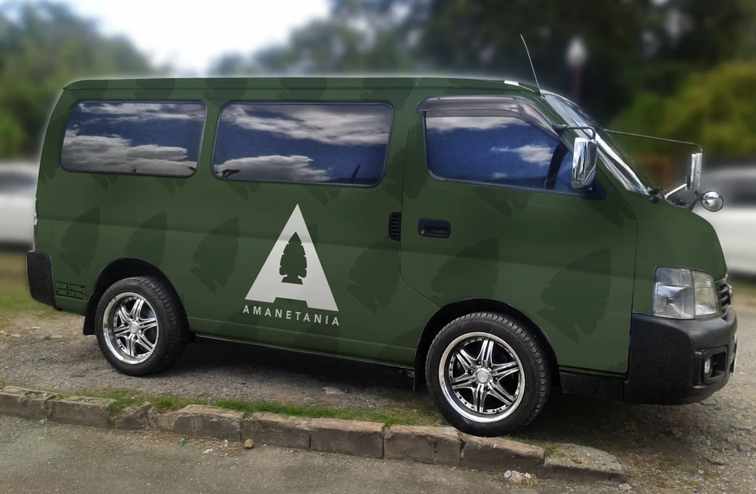 A van wrapped in forest green, the arrowhead pattern running across its panels and the Amanetania mark on the side