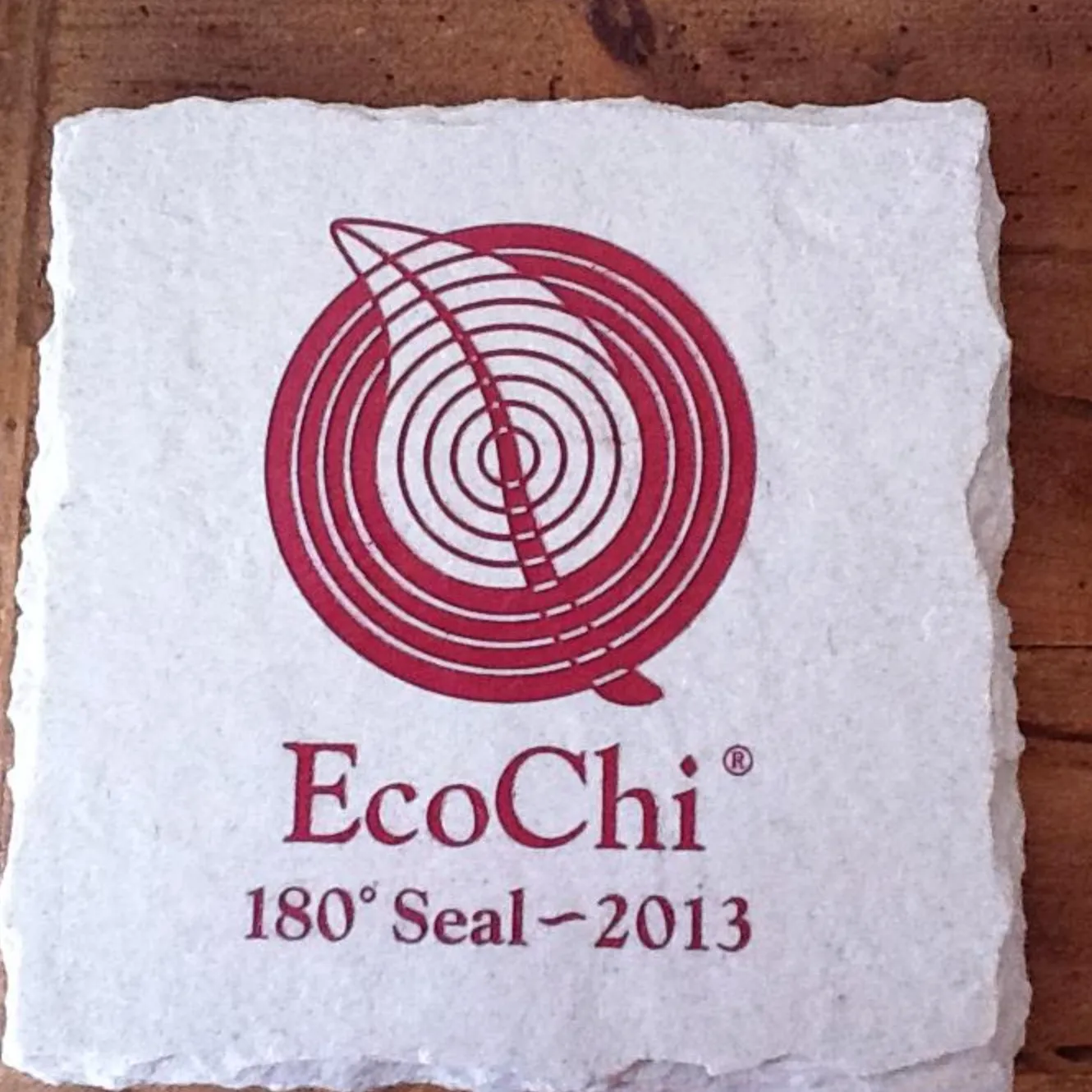The EcoChi seal printed in red on a square of handmade paper, reading EcoChi 180 degree Seal