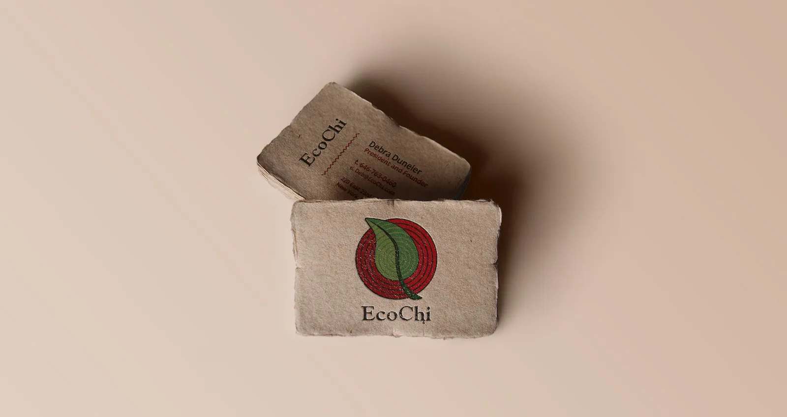 Two EcoChi business cards on handmade deckle-edged paper, one showing the mark and one the contact face