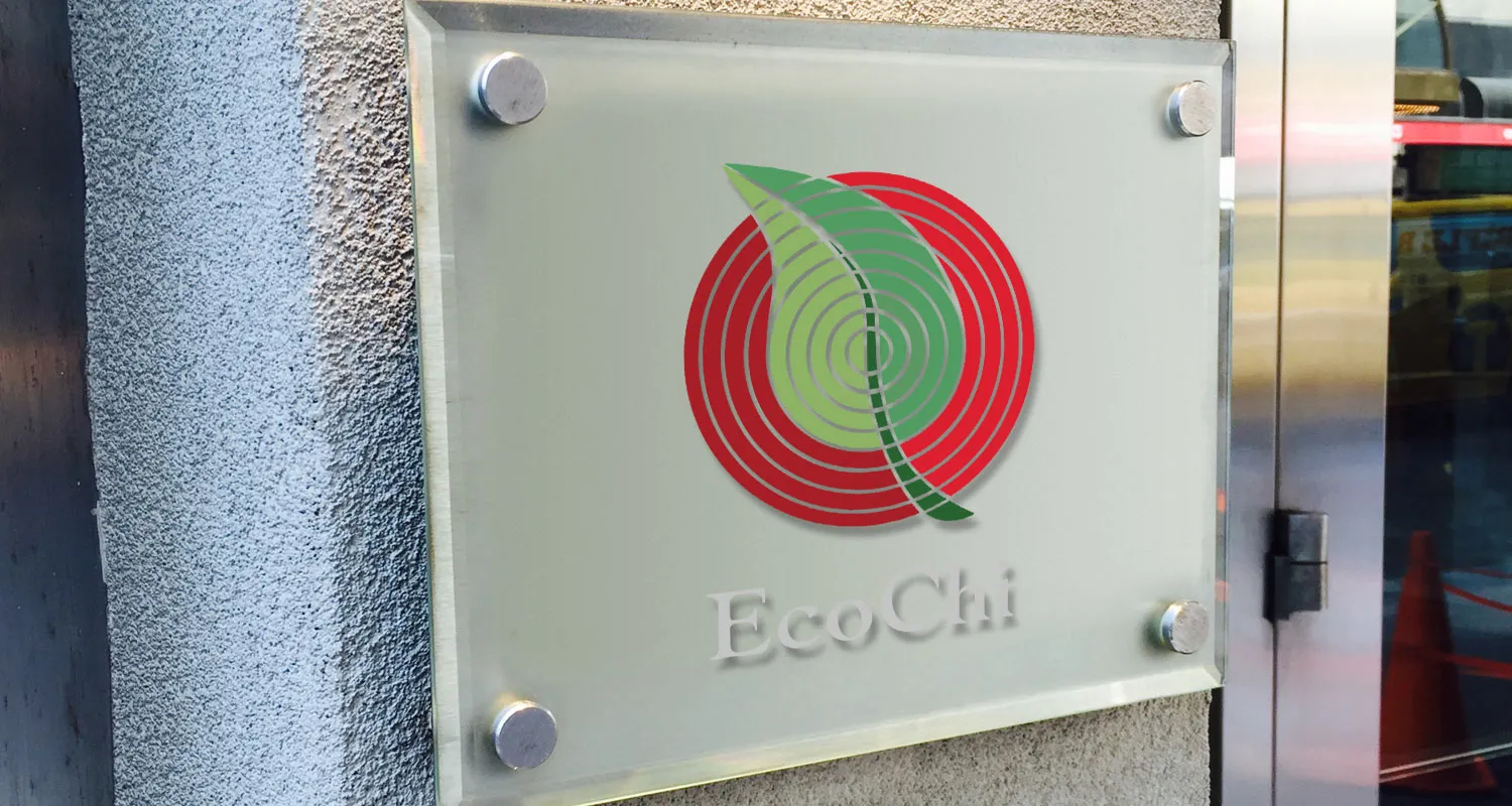 A frosted glass EcoChi plaque mounted on stone beside a building entrance