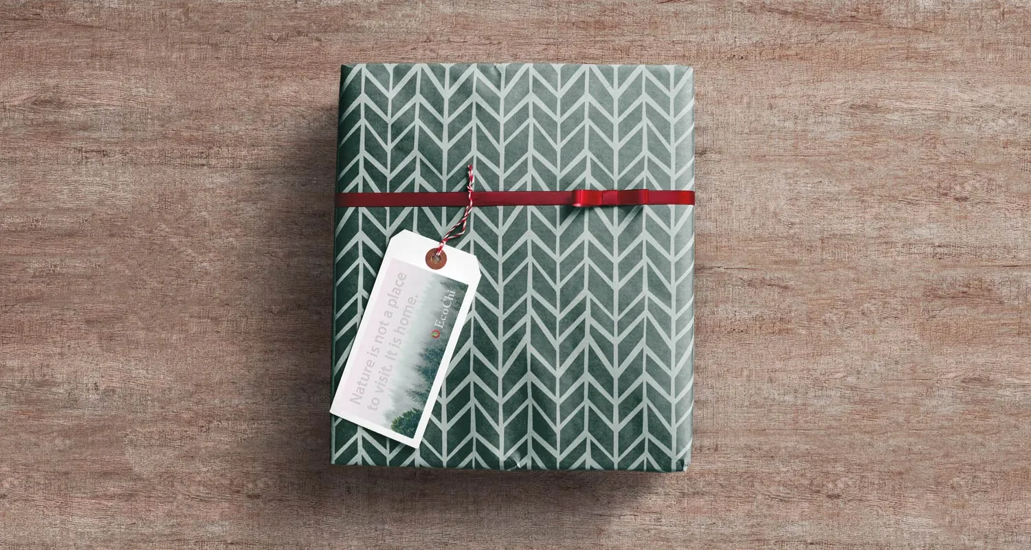 A gift wrapped in EcoChi patterned paper with a red ribbon and a printed tag