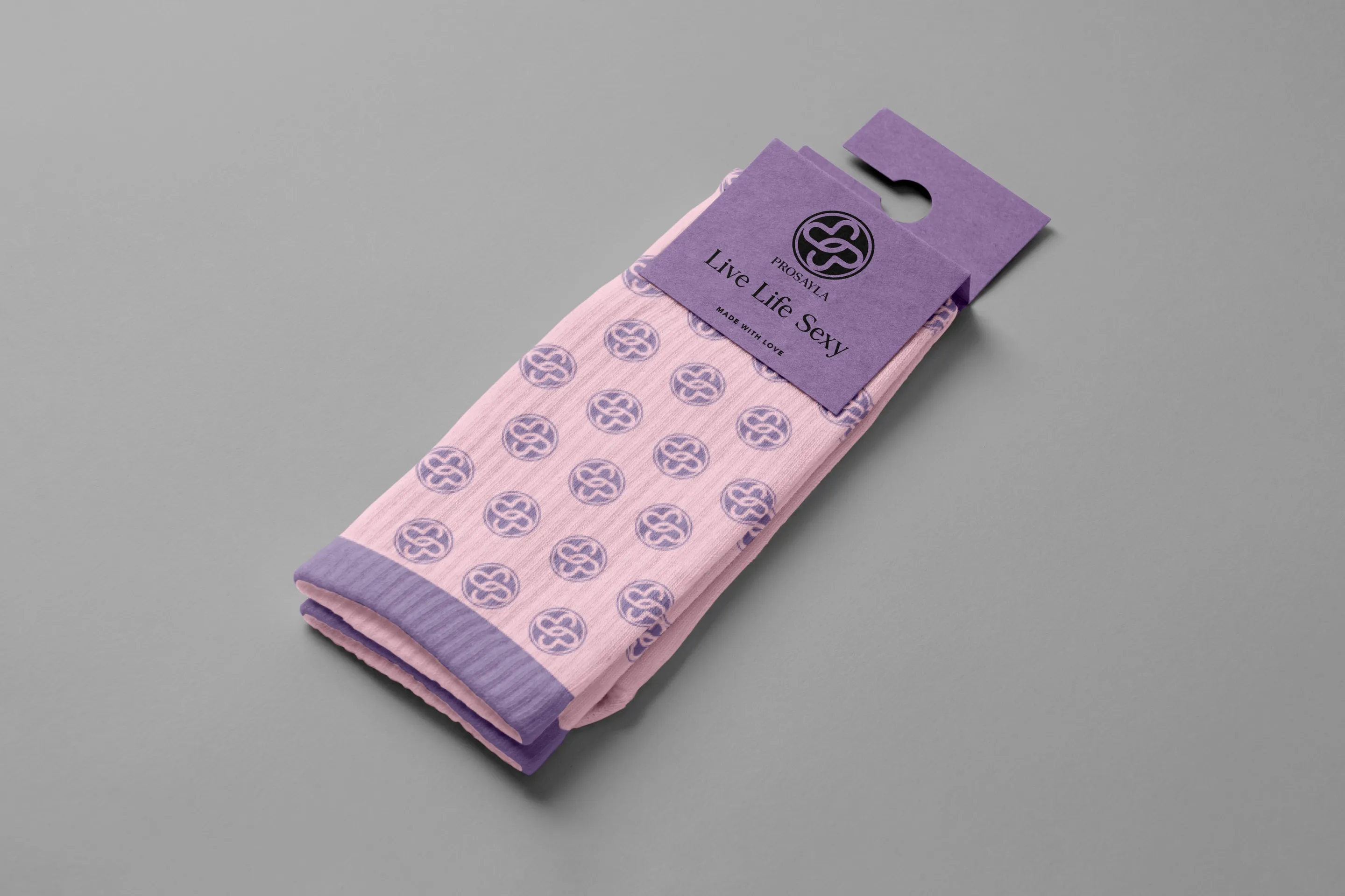 Prosayla merchandise: pink socks patterned with the interlocking mark, folded under a purple sleeve reading Live Life Sexy