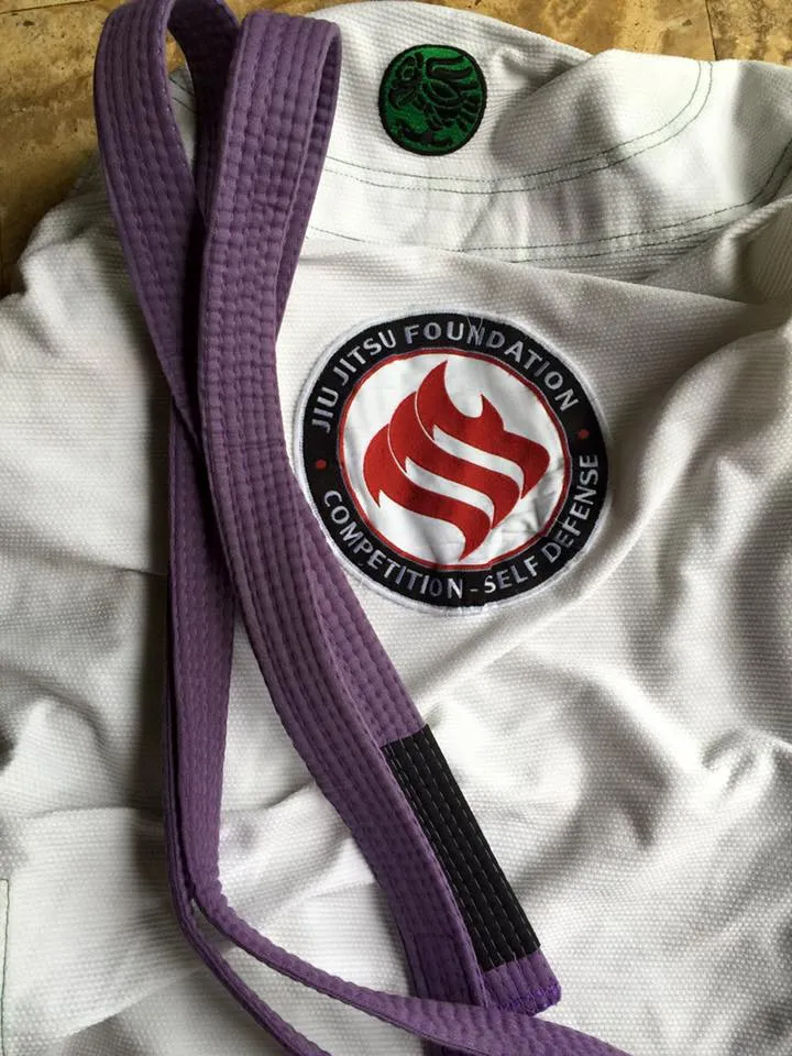 A close view of the patch stitched to a gi, a purple belt resting beside it