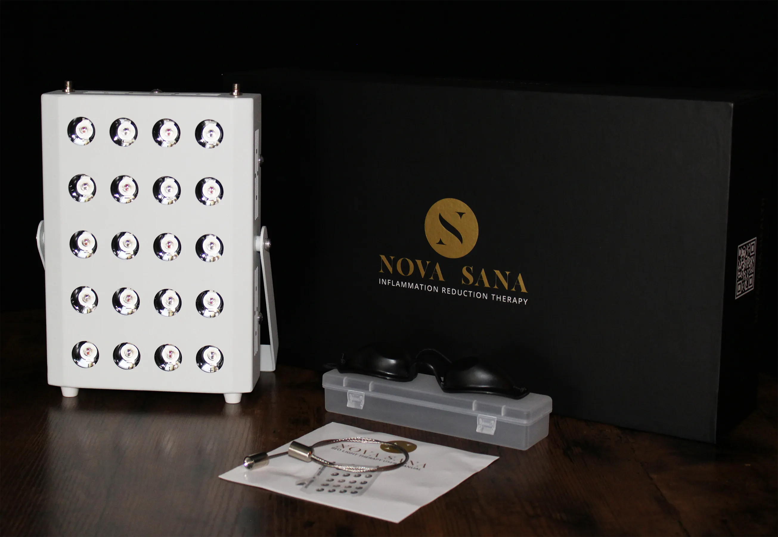The red-light panel beside its black presentation box, goggles and printed manual, the mark in gold across the box