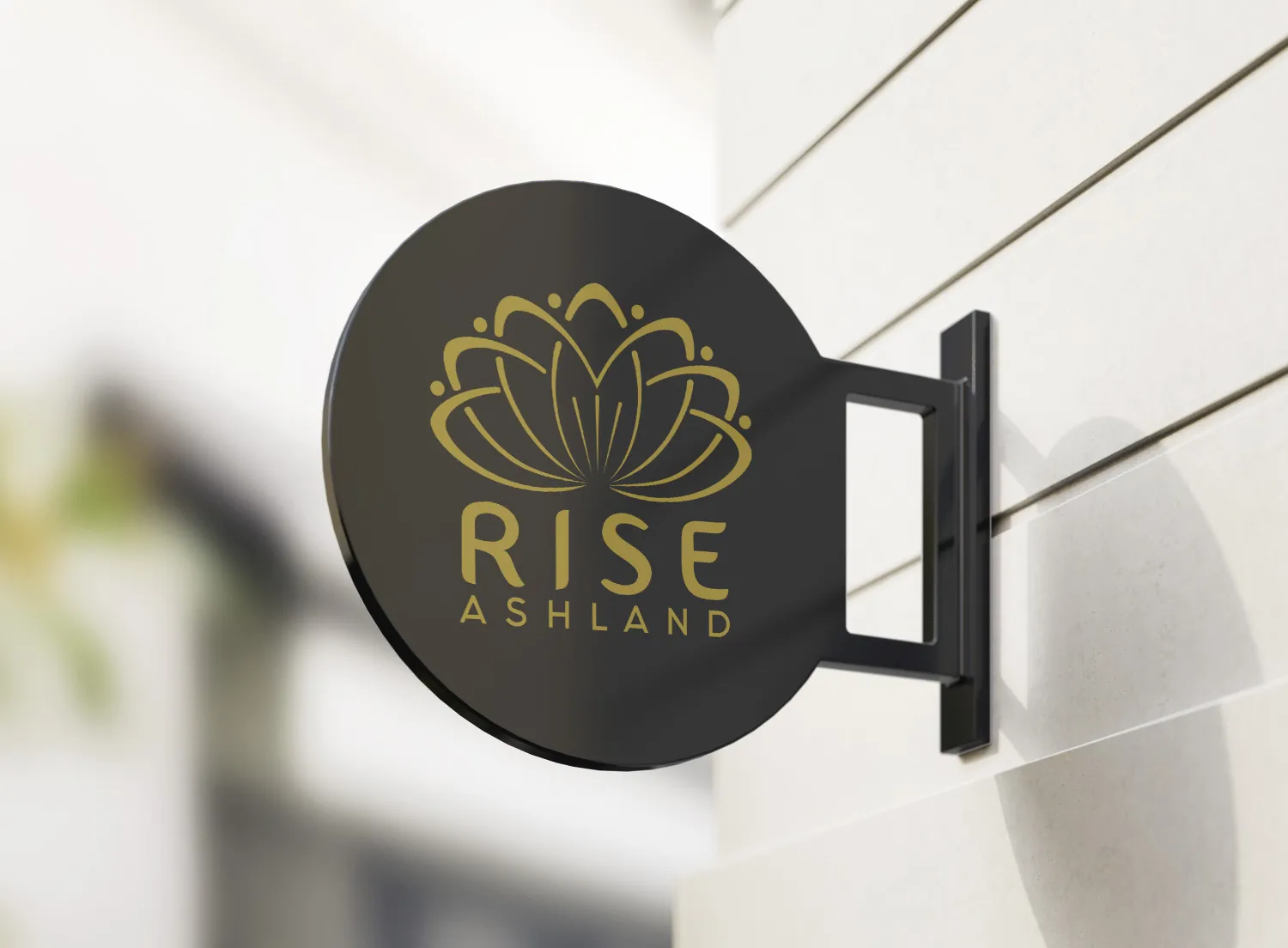 A round blade sign carrying the gold lotus mark, mounted on a bracket beside the entrance