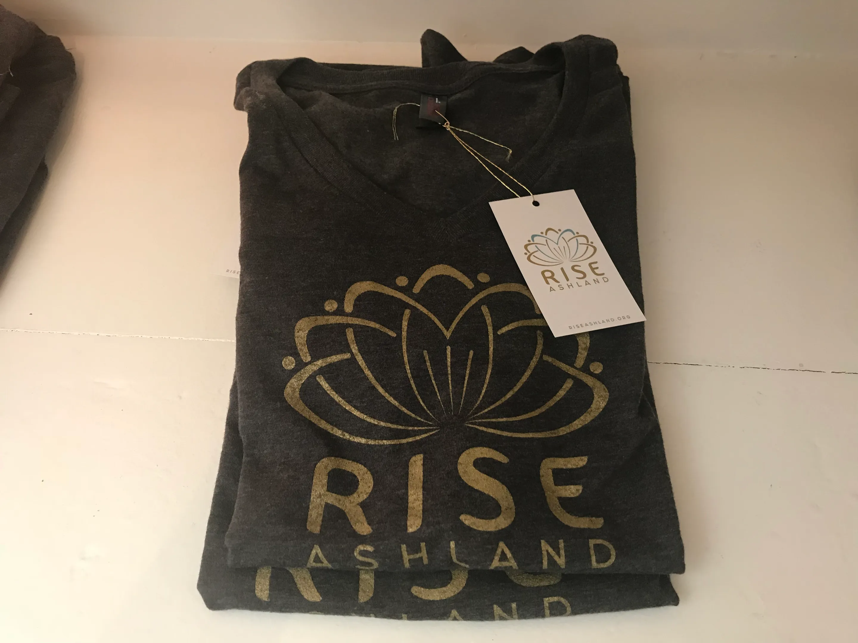 A folded Rise Ashland shirt with its printed hang tag attached