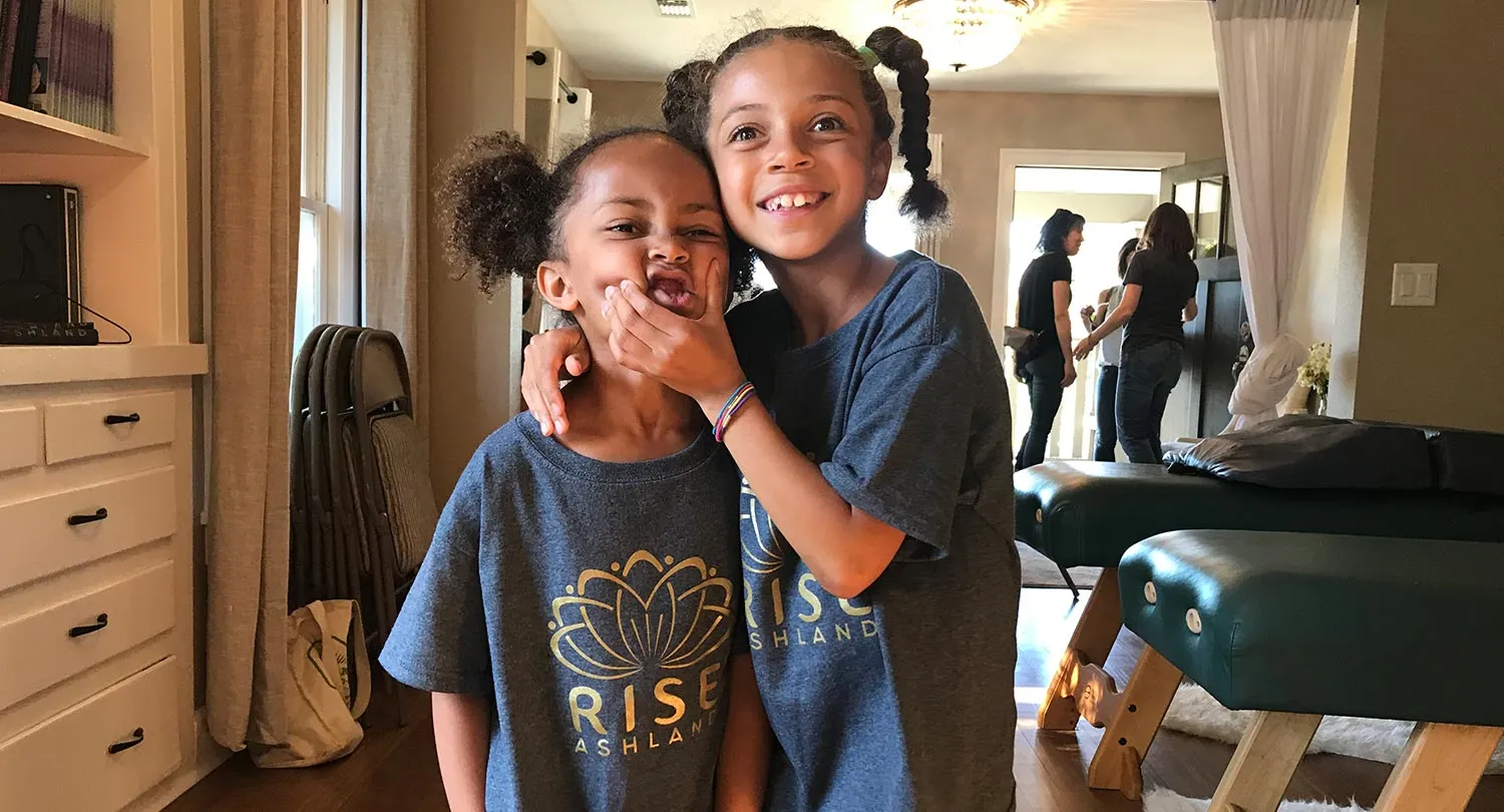 Two children wearing Rise Ashland shirts inside the practice