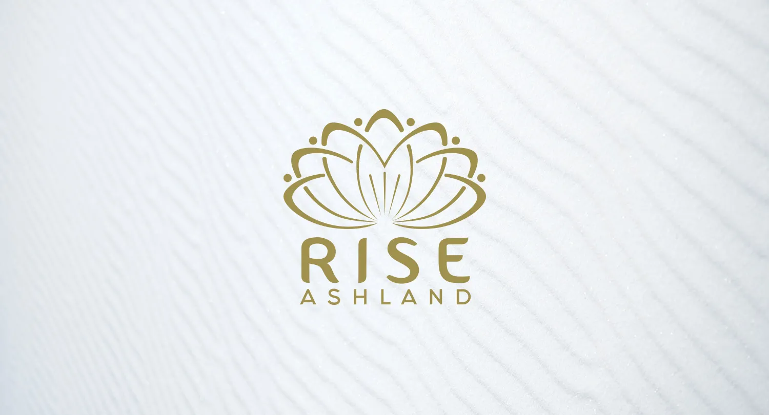 The Rise Ashland logo: a gold lotus mark above the RISE ASHLAND wordmark on a textured white ground