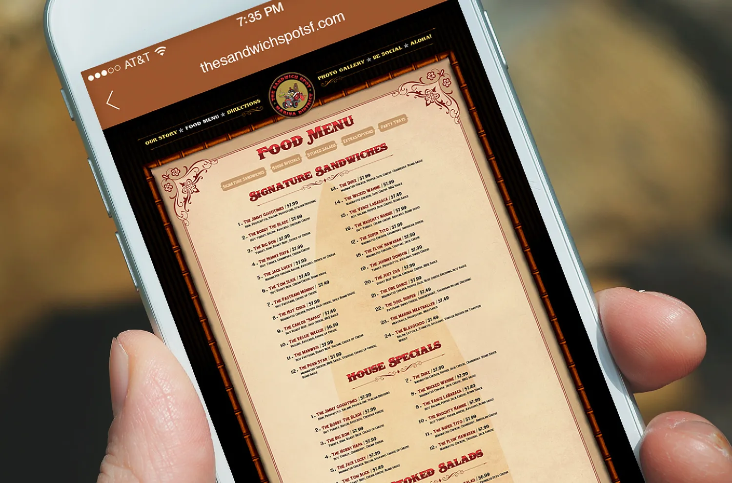 The food menu on the website, shown on a tablet held in one hand
