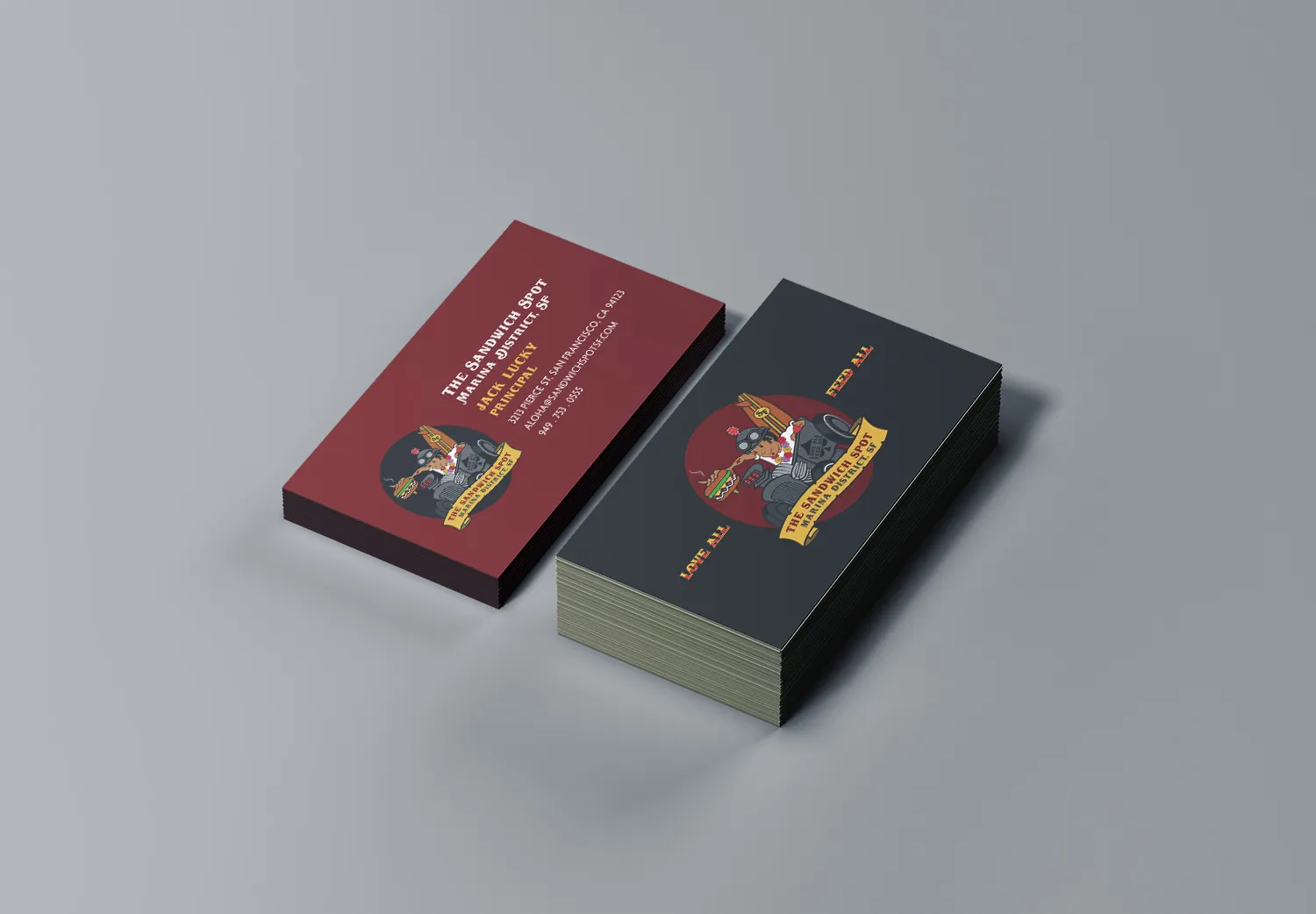 Business cards stacked, showing the dark back and the red front